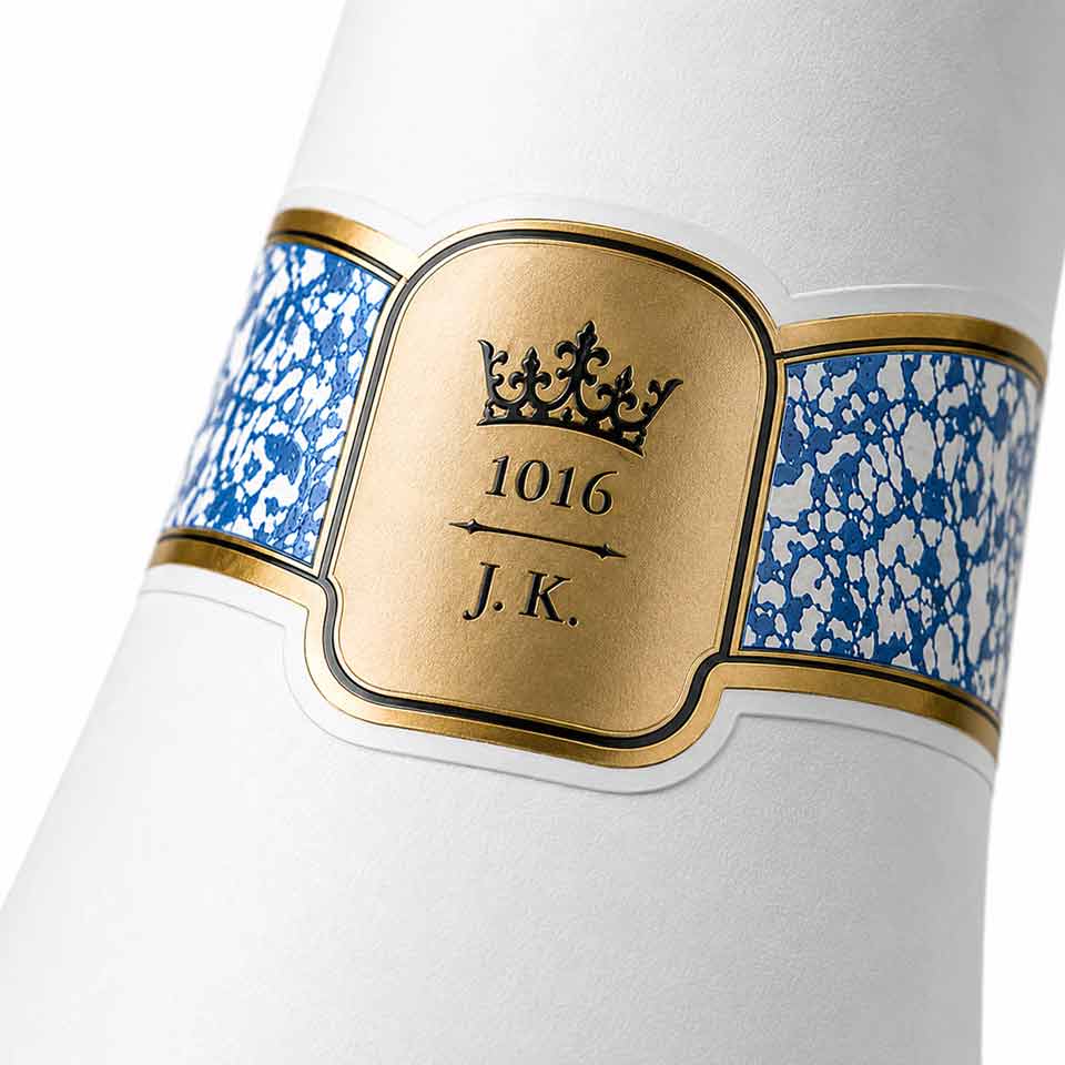 Close up view of the back neck band label for COCO ICE Cava with pattern, gold finish, and emboss. NO IDEA Branding Graphic Design Agency