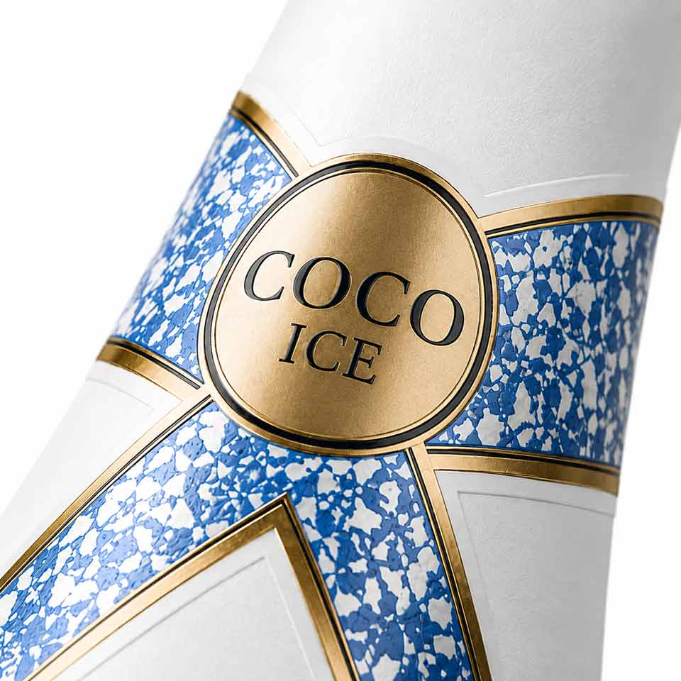 Close-up of sparkling wine neck band label with custom die cut artwork and gold detailing. NO IDEA Branding Graphic Design Agency